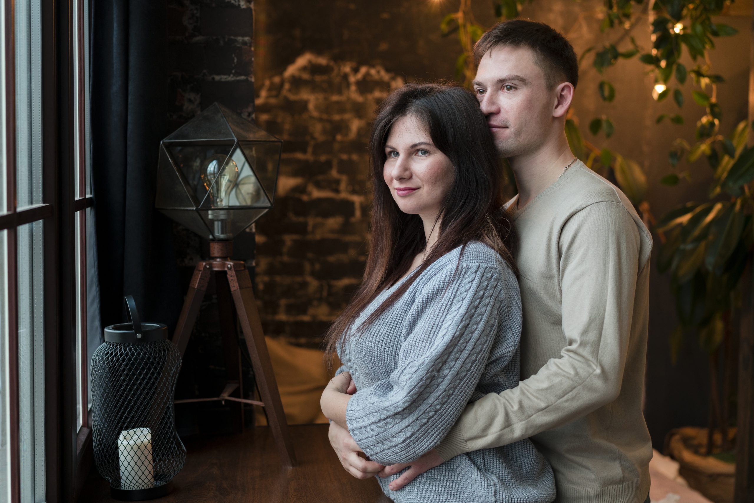 side view couple embrace looking through window scaled